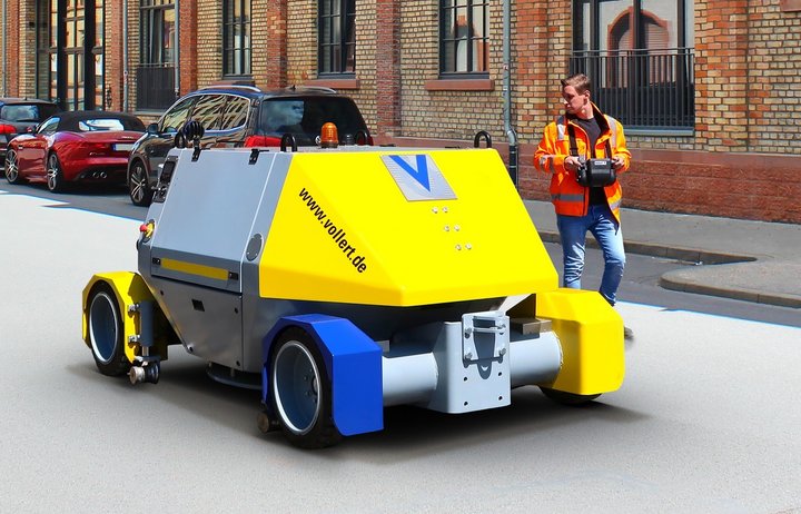Mitarbeiter_steuert_ein_Zweigewefahrzeug_VLEX_20_per_Funkfernsteuerung_auf_der_Straße
