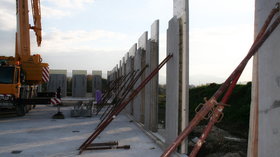 Kernisolierte_Doppelwände_aufgestellt_auf_der_Baustelle_und_gestützt_mit_Baustützen