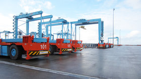 Batteriewechselstation_mit_drei_nebeneinanderstehenden_AGVs_auf_dem_HHLA Container _Terminal