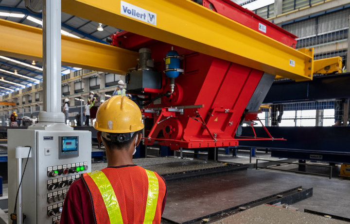 Mitarbeiter_bedient_am_Steuergerät_einen_SMART_CAST_Betonverteiler_bei_DSC